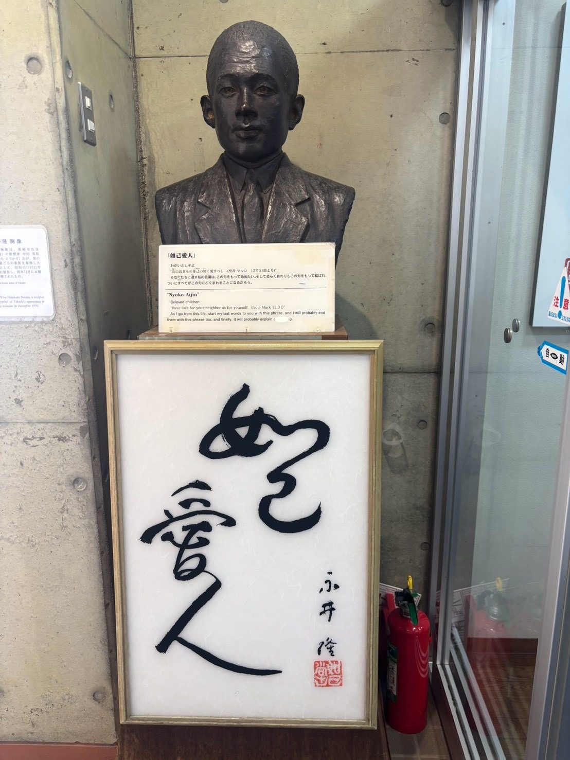 永井隆の胸像と、永井隆が書いた「如己愛人」の書