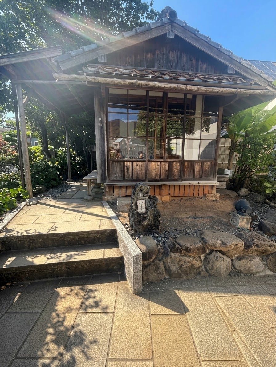 木々に囲まれた小さな木造の家、如己堂の外観